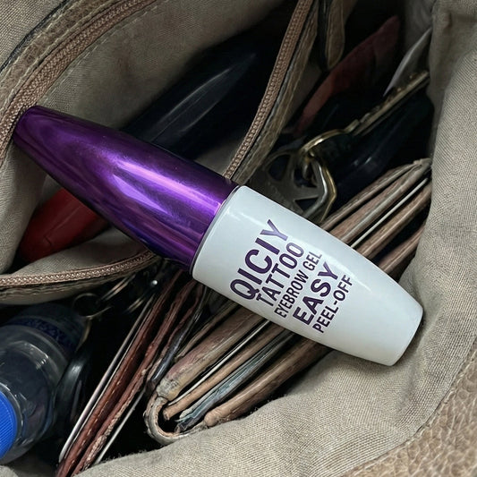 Purple and white bottle of Olay Total Effects 8-in-1 Serum in a brown leather bag.